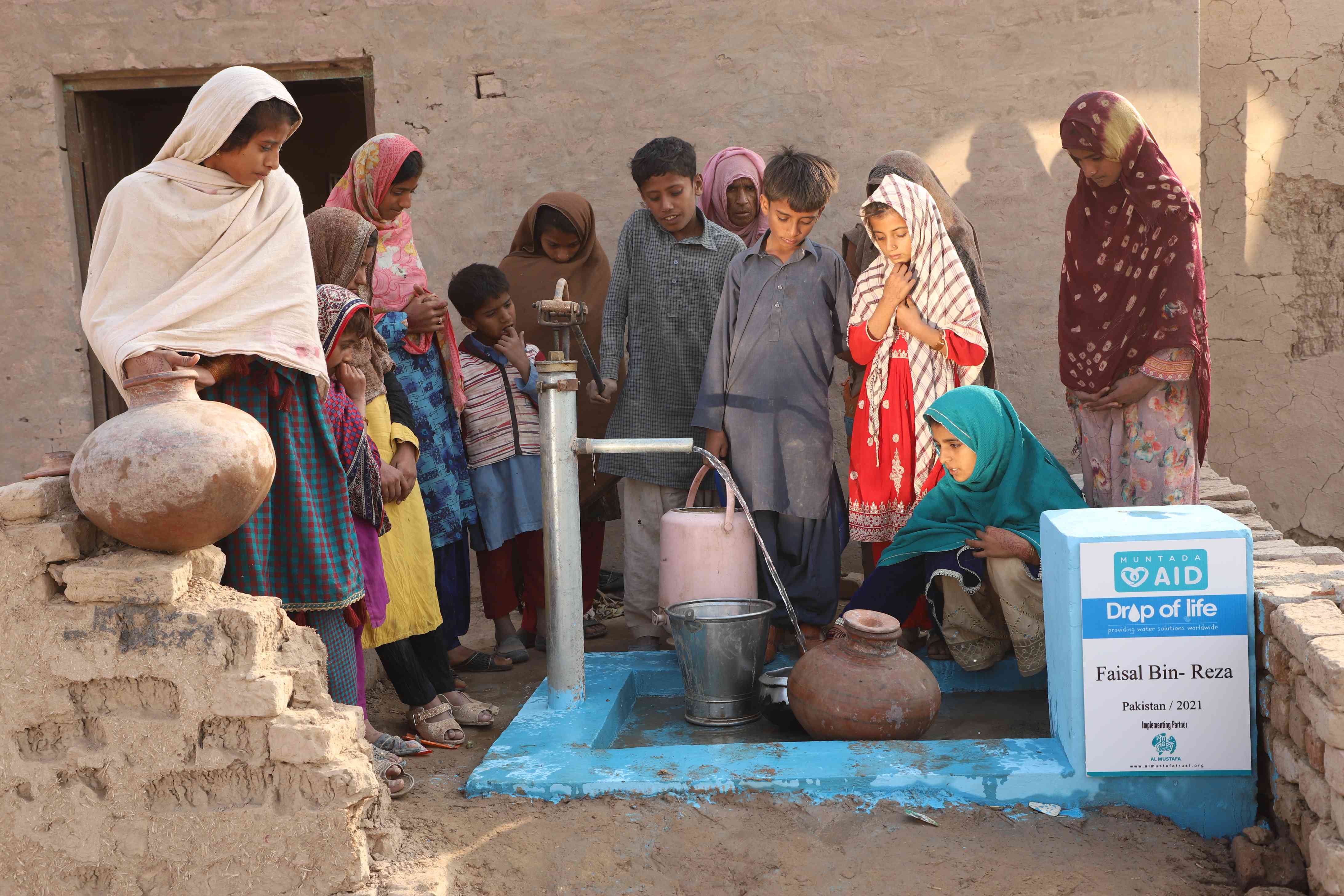 People gathering around a tube well in Asia